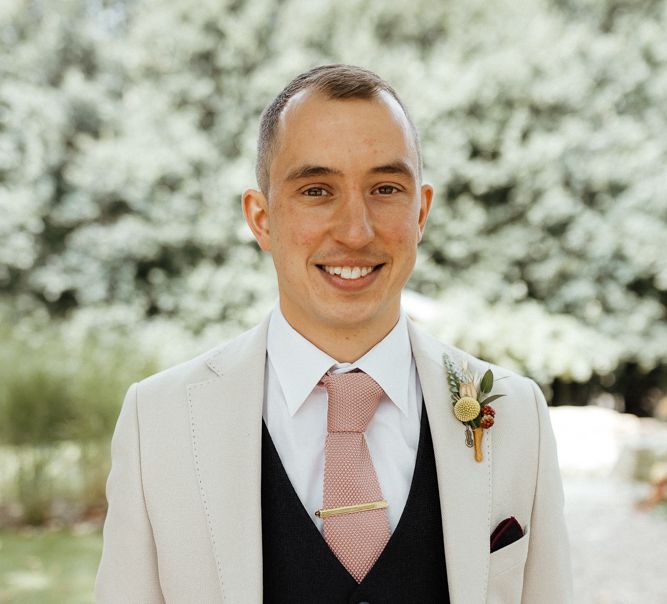 Groom in a white shirt, pink tie, navy waistcoat and cream blazer | Caitlin and Jones Photography