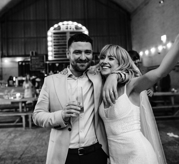 Black and white image of the happy couple with bride holding up champagne glass