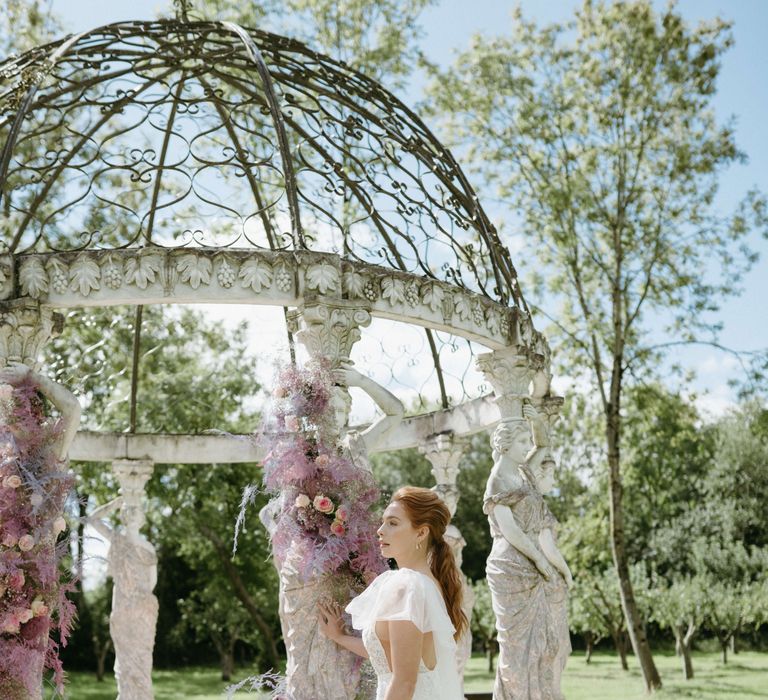 Bride looks away from camera wearing white lace gown during Spring