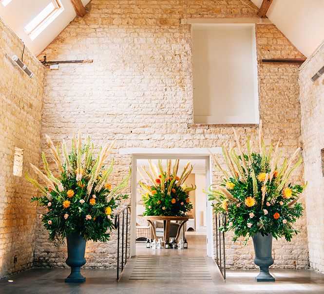 Extravagant peach wedding flower installations with pampas grass in country barn 