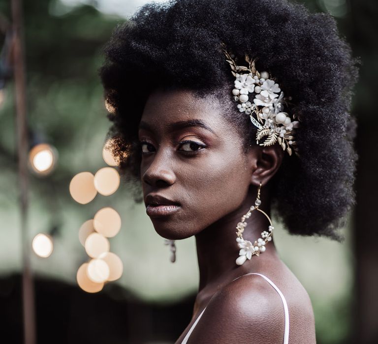 Black bride with afro hair wearing hoop earrings and matching hair slide bridal accessories 