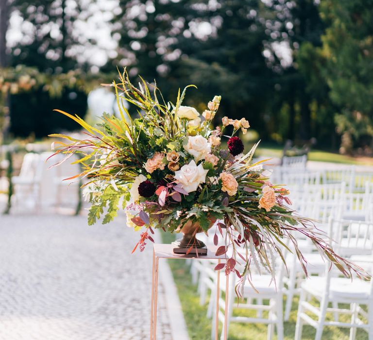 Floral bouquet of white roses, wild grass, blush carnations and red dahlias