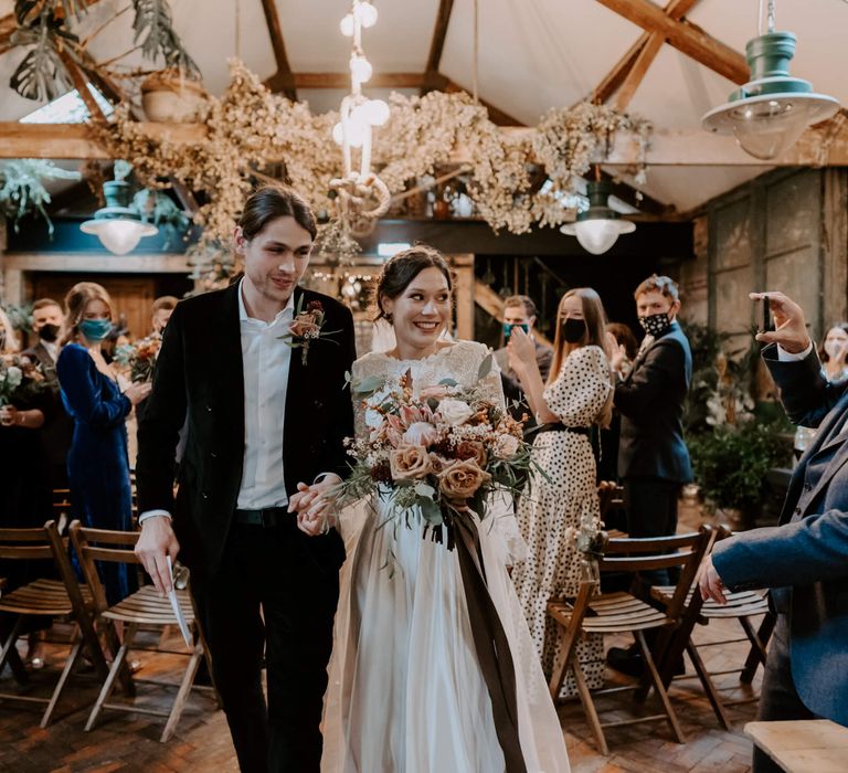 Bride and groom walking down the aisle at Clapton country club festive wedding