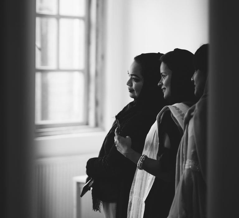 Black and white portrait of wedding guests looking at the bride on the wedding morning