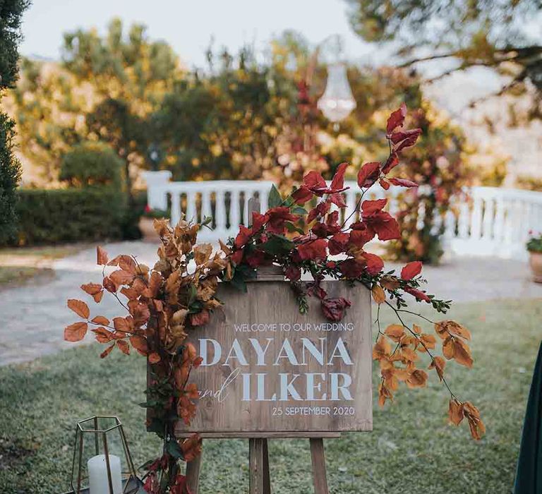 Wooden wedding welcome sign with Autumn colour wedding flowers