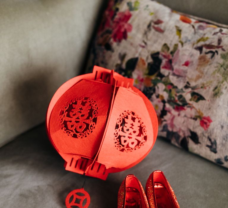 Red Chinese lantern next to red wedding shoes