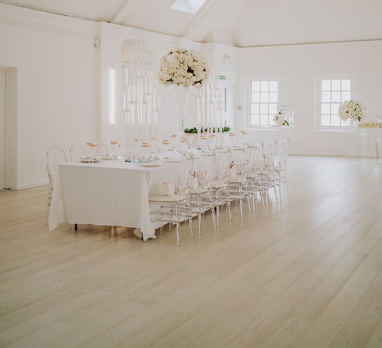 Core Clapton reception venue with white colour scheme and luxe floral decor featuring white roses in large vases