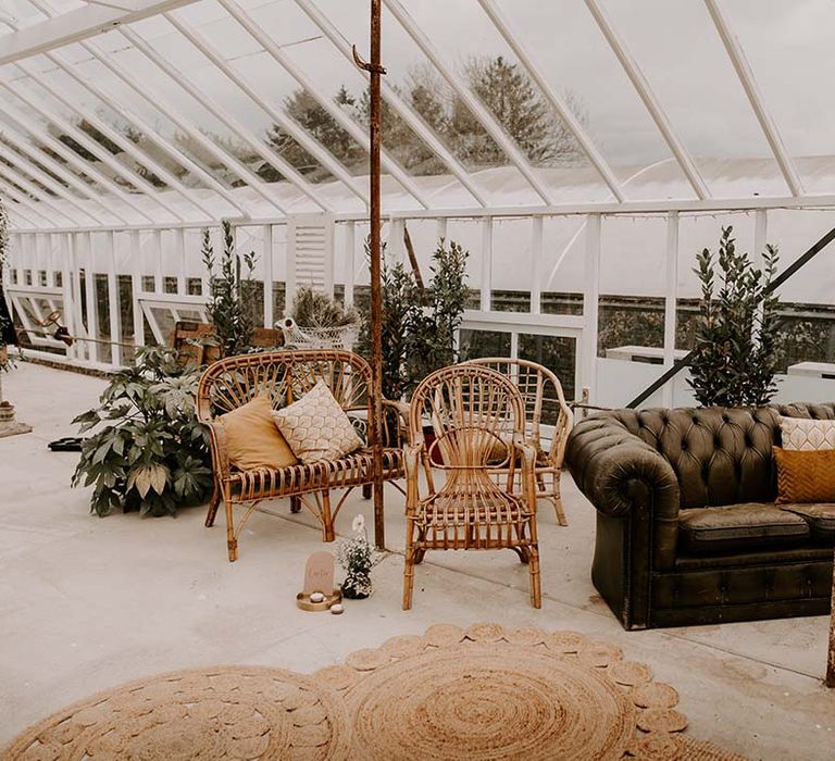 Vintage leather sofa and wicker ceremony chairs in the conservatory at The Gooseberry House 