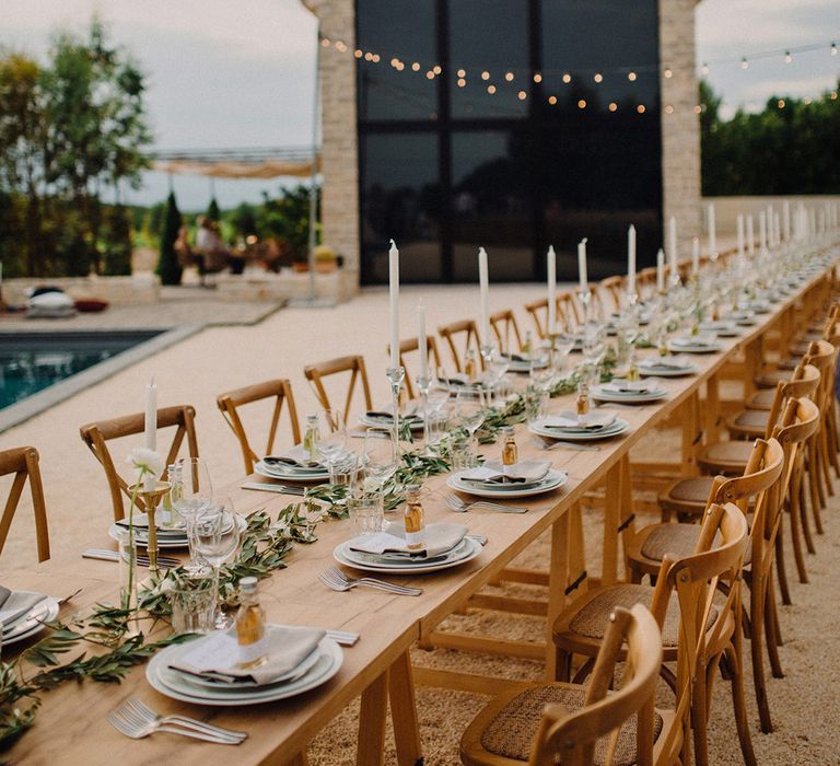 Rustic outdoor table setting complete with olive branch table runner