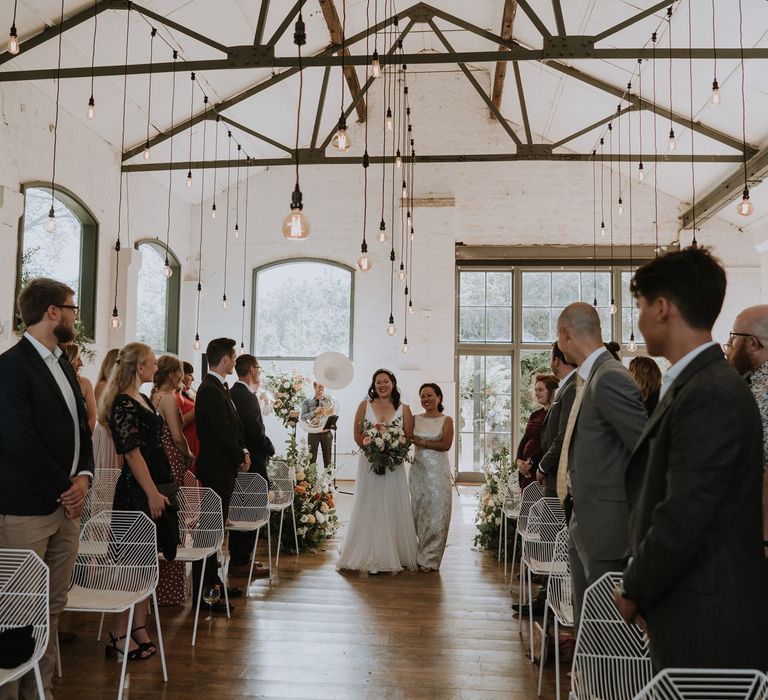 Mother of the bride walking her daughter down the aisle at an Osea Island wedding 