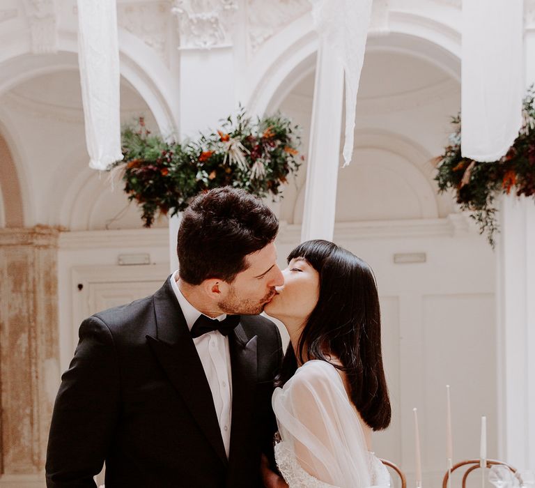 Bride and groom kissing at a minimal wedding inspiration shoot with neutral decor 