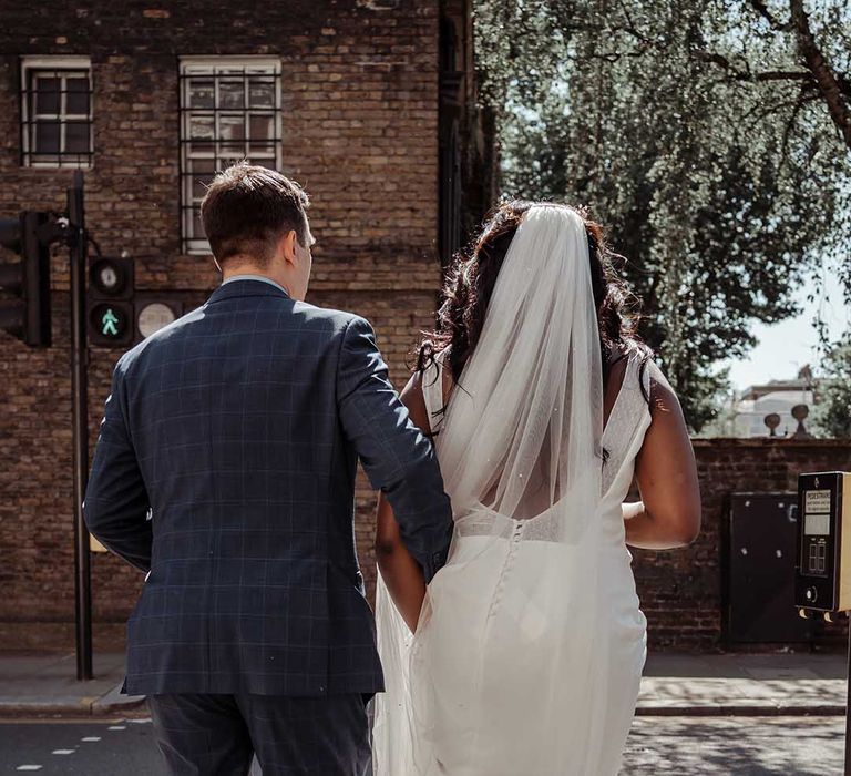 Bride & groom walk away together arm in arm on their wedding day