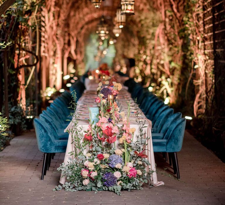 Hot pink and orange wedding decor complete with emerald blue chairs and hanging lanterns