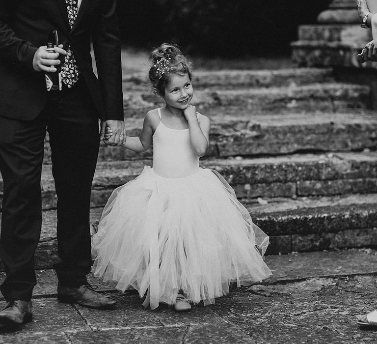 Flower girl wears tutu dress complete with her hair up