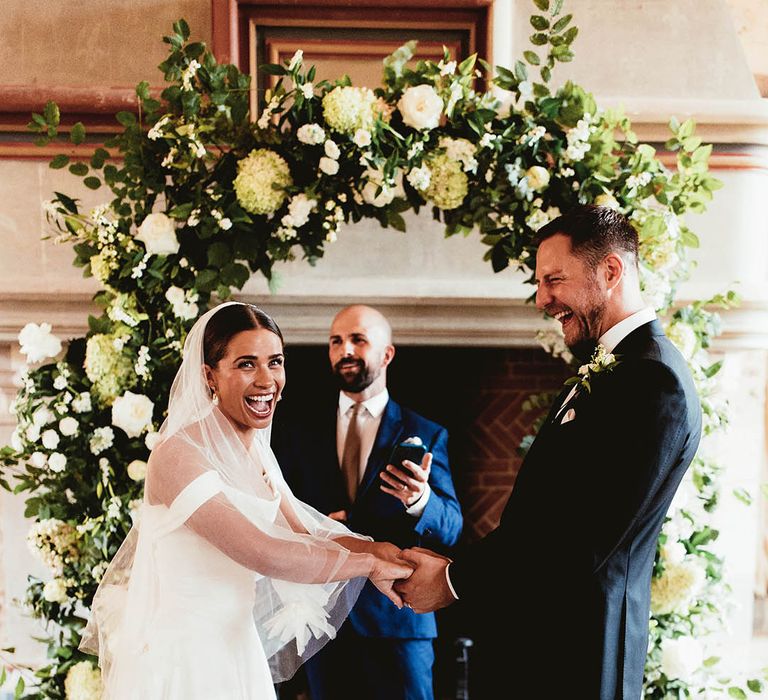 Bride & groom hold hands during wedding ceremony