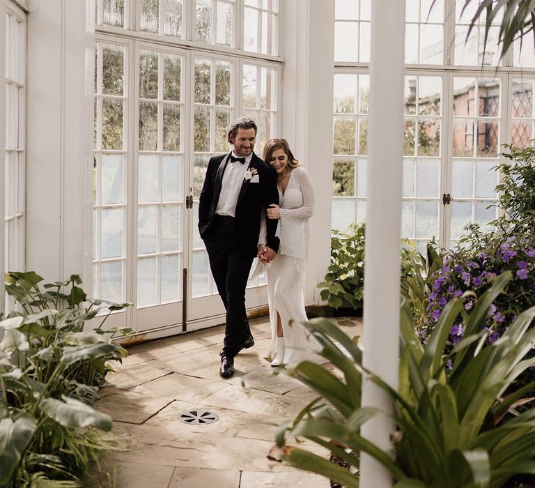 Conservatory at Tatton Park wedding venue with bride and groom in black-tie attire 