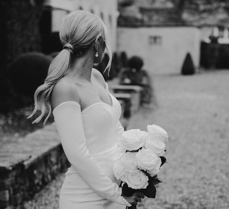 Sleek wavy ponytail bridal up do for black tie wedding at Northbrook Park with bride in a strapless wedding dress. 