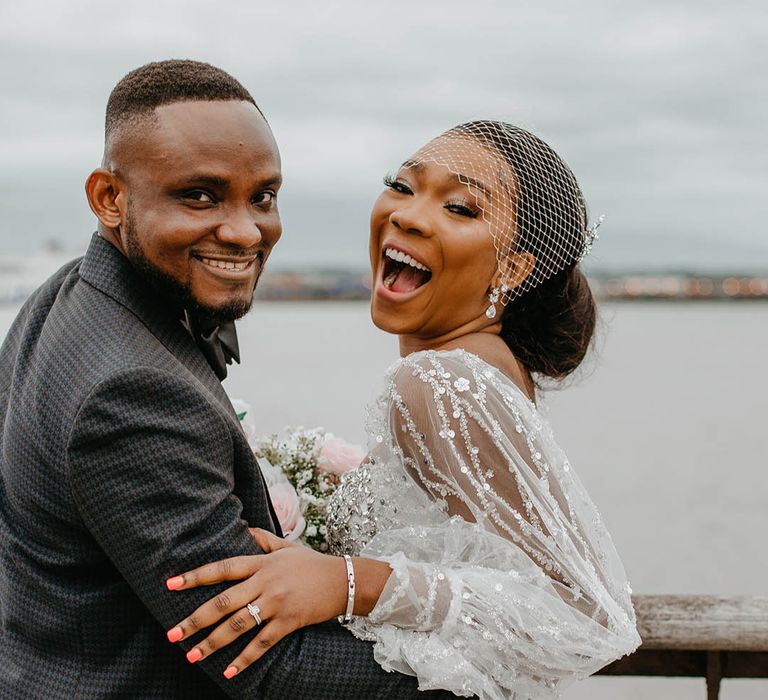 Bride & groom laugh with one another in Liverpool for couples portraits