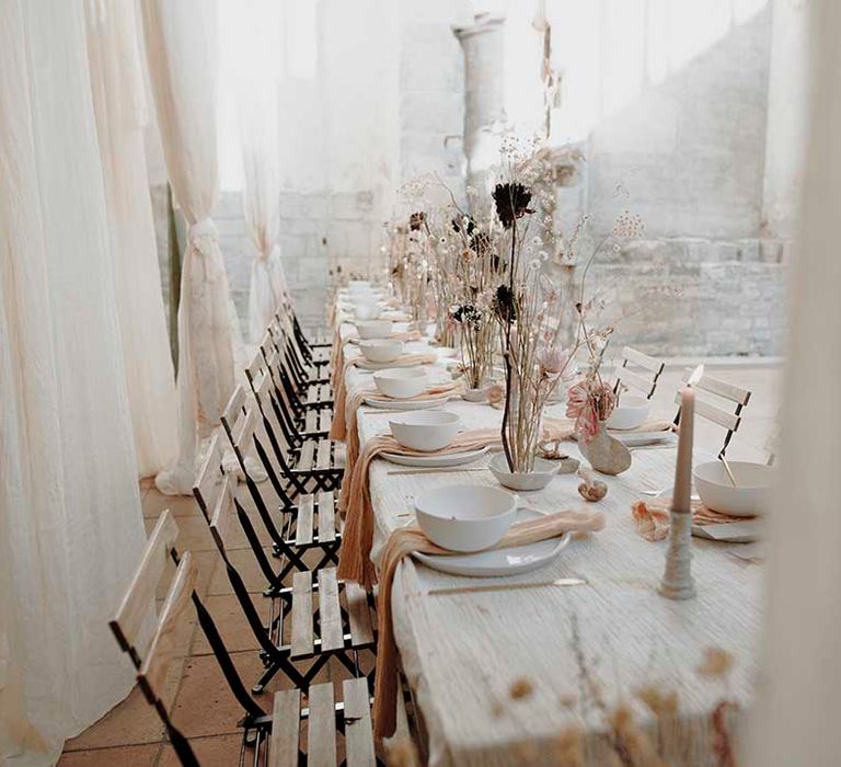 Place settings with charger plate, natural linen napkin, bowl and gold cutlery 