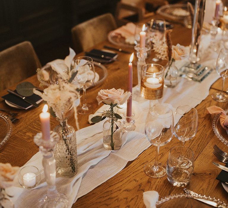 wedding table decor with table runner, candles and flower stems in vases