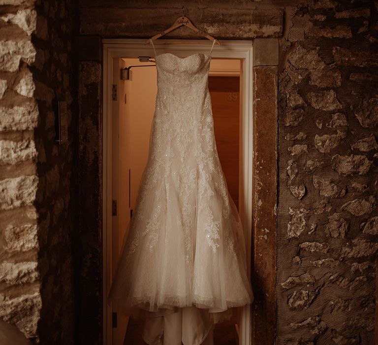 Wedding gown hangs on the morning of wedding day