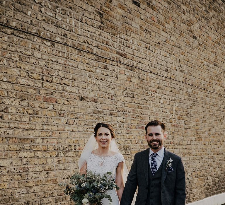 Bride & groom walk with one another outdoors on their wedding day