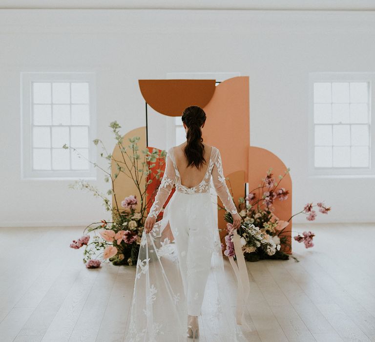 Asian bride wear suits trousers and low back sheer top that drapes at her asian decor wedding