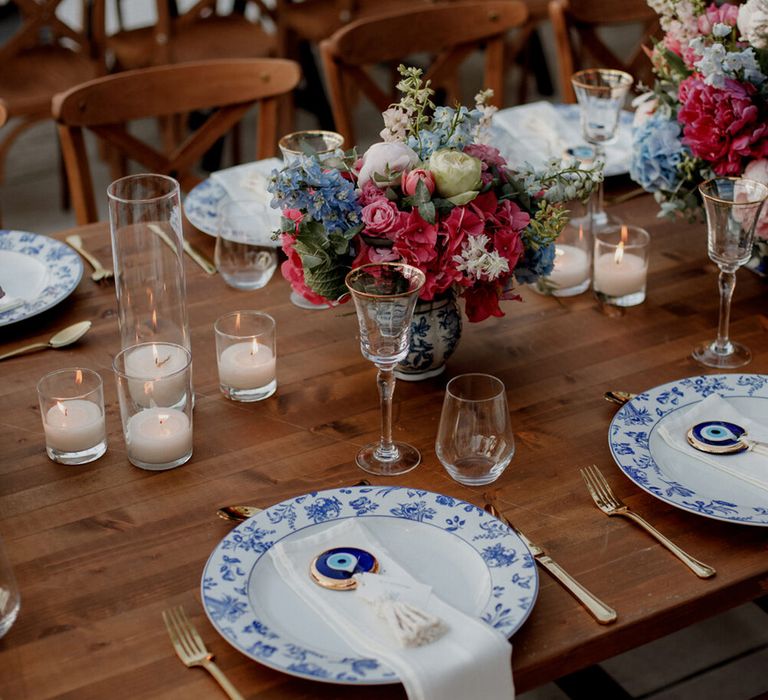 White and blue china plates complete with evil eye decorative piece and candles