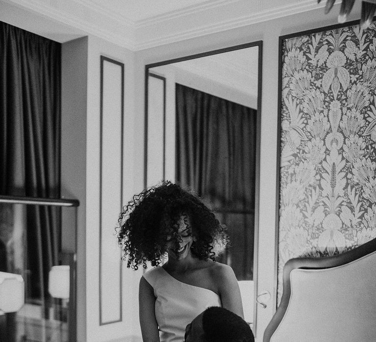 Black bride with naturally curly hair wearing a one shoulder wedding dress at Mayfair Townhouse 