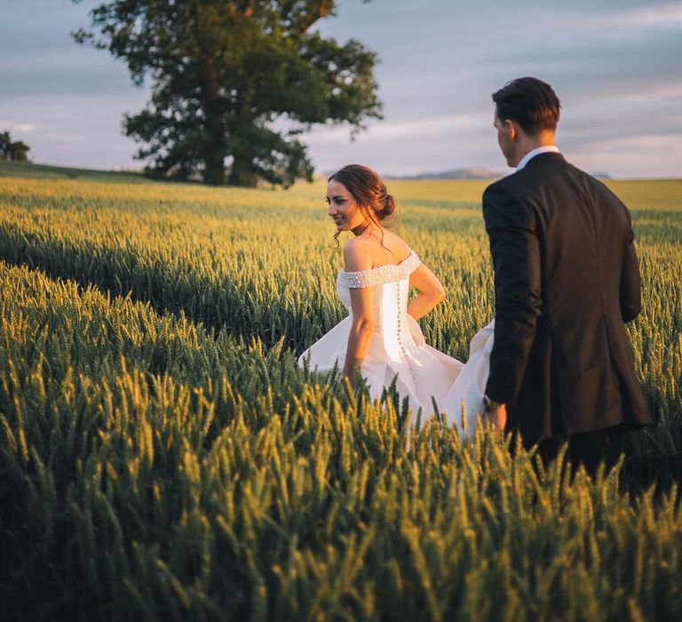 Bride and groom take a stroll together through the grounds at Dewsall Court