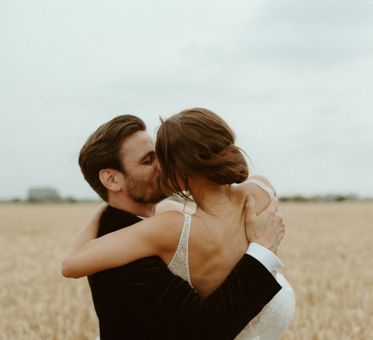 Groom lifts the bride and they share a kiss