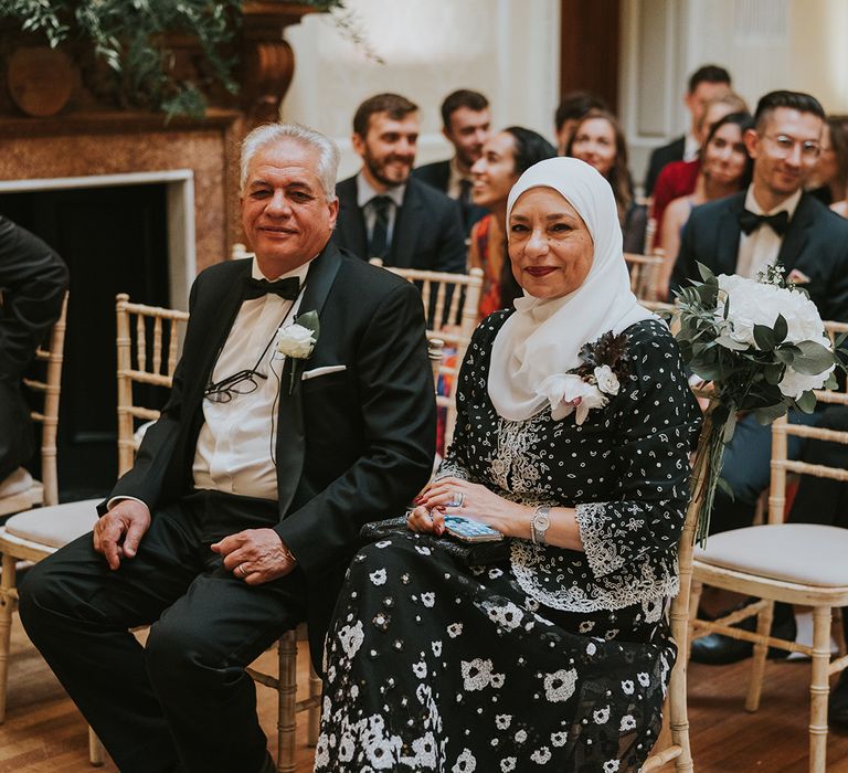 Wedding guests and family members sit watching the wedding ceremony 