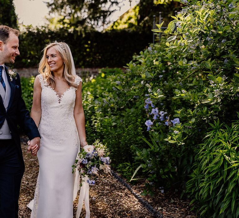 Bride looks into the groom's eyes as they walk together for their couple portraits 