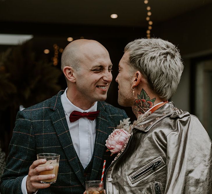 Groom wears red bow tie and tartan blazer with white shirt 