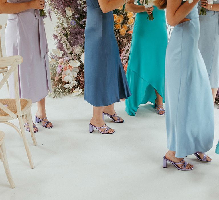 Bridesmaids in blue dresses and matching metallic purple heels