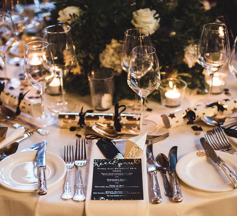 Black, white and gold wedding tablescpae with Christmas crackers