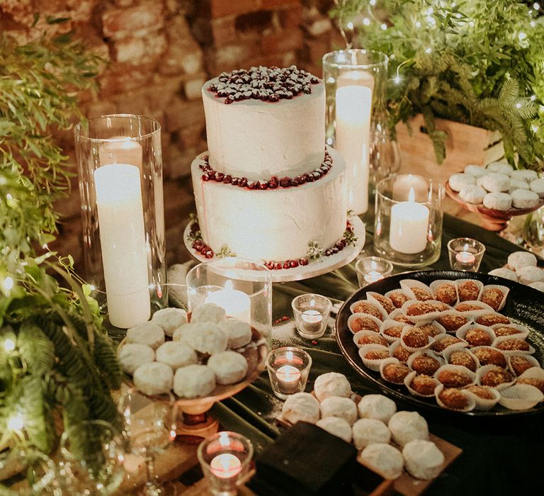 Two tier white iced wedding cake with berries and powdered sugar for decoration 