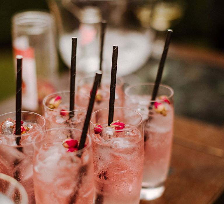 Pale pink ice cold mocktail with mini pink roses in the drink