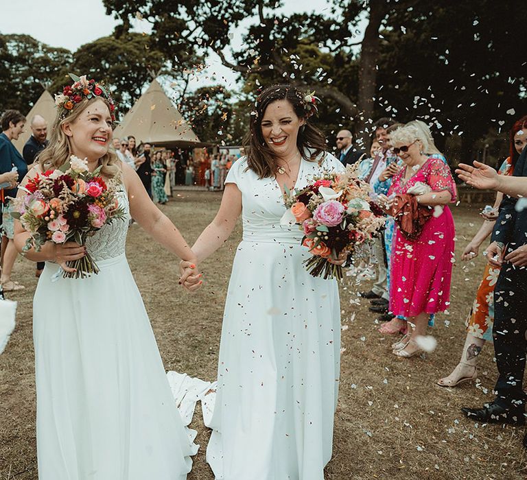 Colourful confetti exit for the two brides at their tipi wedding 