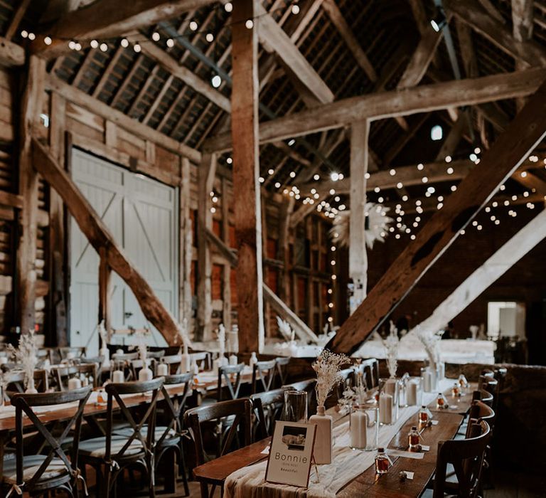 Pimhill Barn rustic wedding venue with neutral minimal styling including lots of white pillar candles, table runners, dried flowers and pampas grass