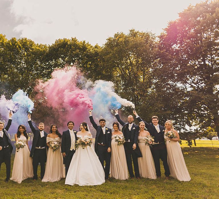 Win wedding photography from We Are // The Clarkes. Here is a creative wedding photo showing the wedding party letting off multicoloured smoke bombs