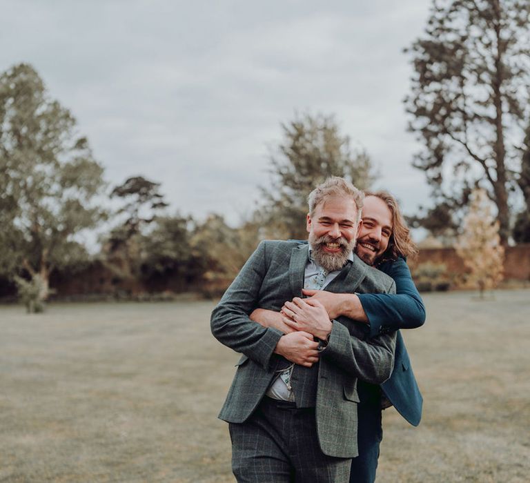 Queer grooms embrace outdoors for couples portraits in Kew Gardens for botanical wedding 