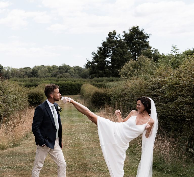 Chloe Bruce martial arts coach jokingly kicks her husband during outdoors couples portraits 