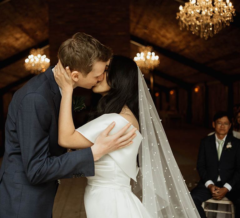 The bride and groom share their first kiss as husband and wife for their rustic luxe wedding at Hidden River Cabins in the North West