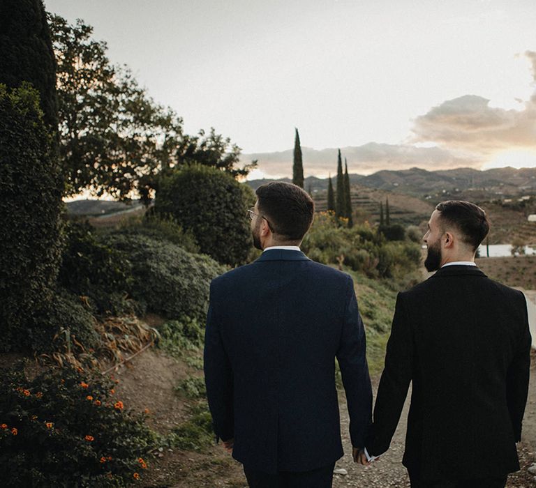 Two grooms holding hands at their Spanish destination wedding 