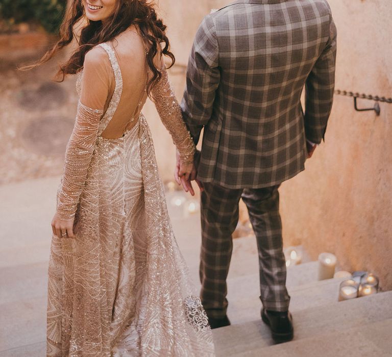 bride in a gold wedding dress and groom in a grey check suit at their Carmen de los Mártires Spanish wedding venue