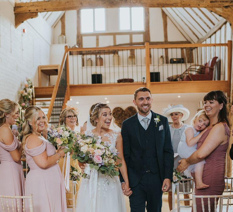 The bride and groom walk back down the aisle as a married couple at Dove Barn for their rustic wedding 