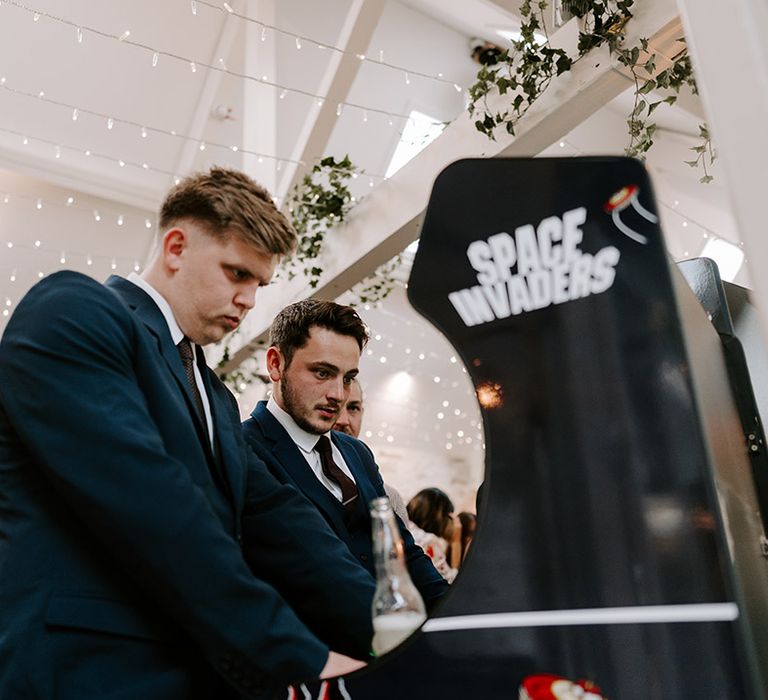 Wedding guests plan arcade games at the wedding reception 