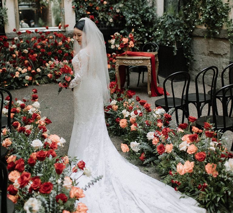 Red, orange, and white wedding flowers lining the aisle and altar at Brix & Mortar in Vancouver with the bride in mermaid lace wedding dress 