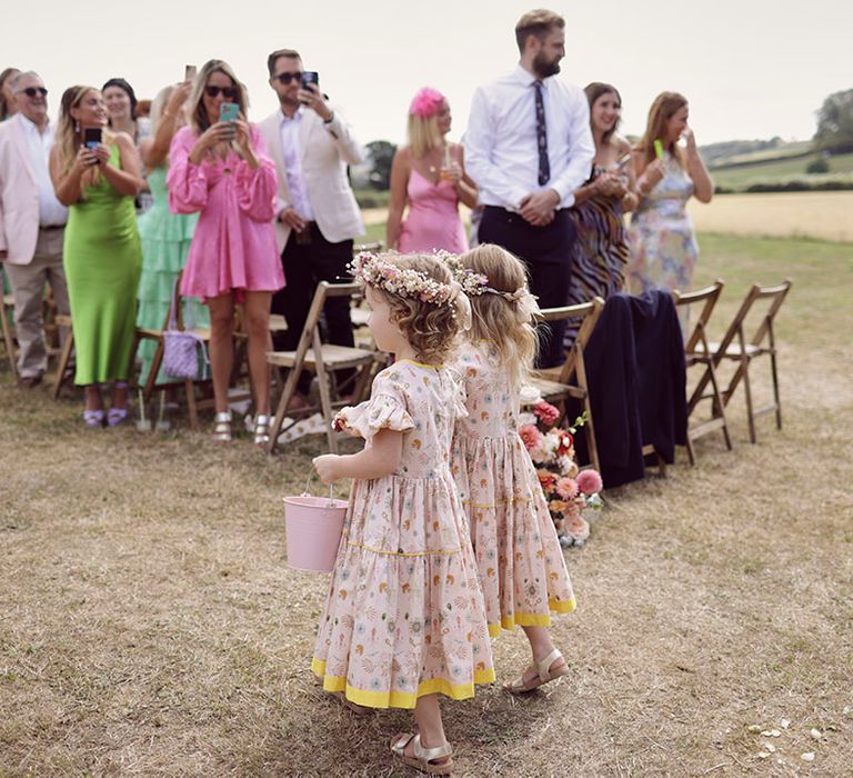 Flower girls in pretty floral flower girl dresses and flower crowns 